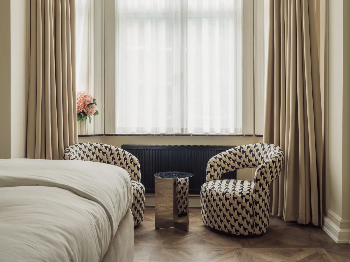 Czarny grzejnik Purmo Compact we wnęce okna w pokoju hotelowym
